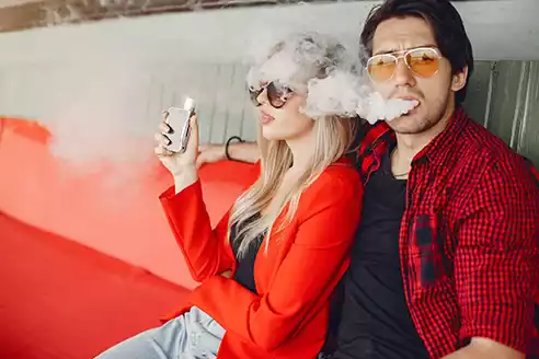 genc kız ve genç erkek ellerinde puff bar elektronik sigara kullanıyor